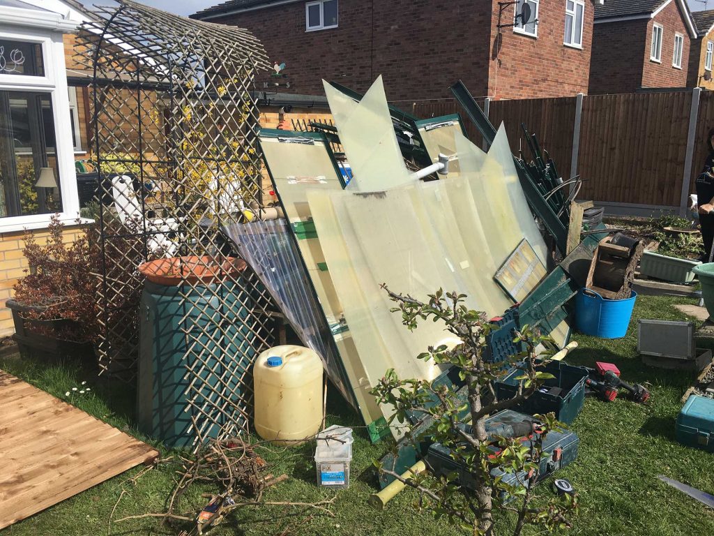 building materials and garden waste in a cluttered back garden