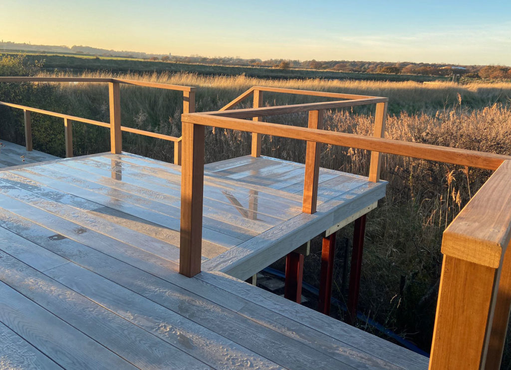view from raised deck over wetland scene at sunset