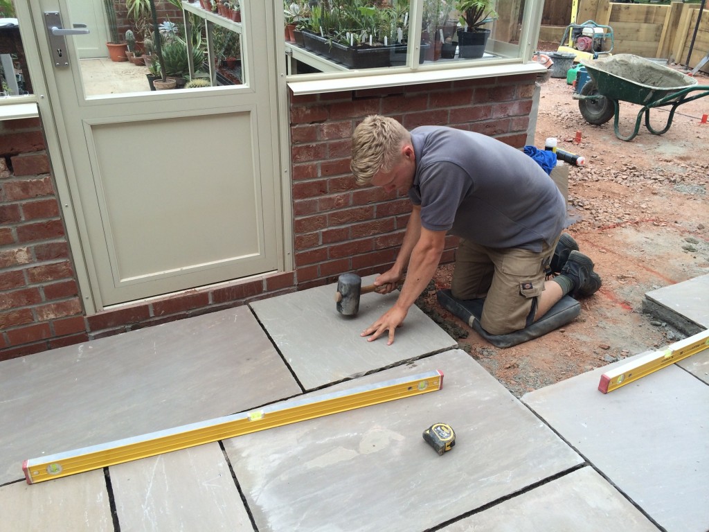 landscaper laying slabs