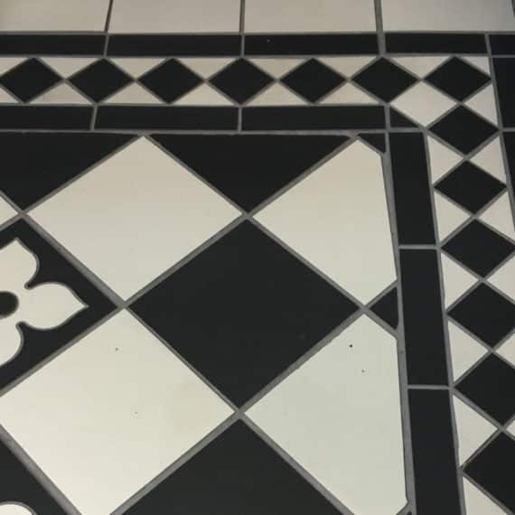 corner detail of black and white ceramic tiled external pathway