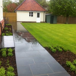 beautiful garden with black pavers and perfect lawn