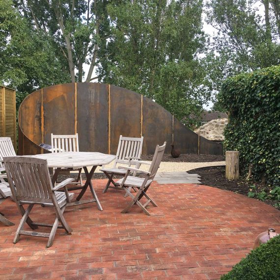 intimate seating area in an award winning garden in Essex. Patio has been created using red clay pavers.