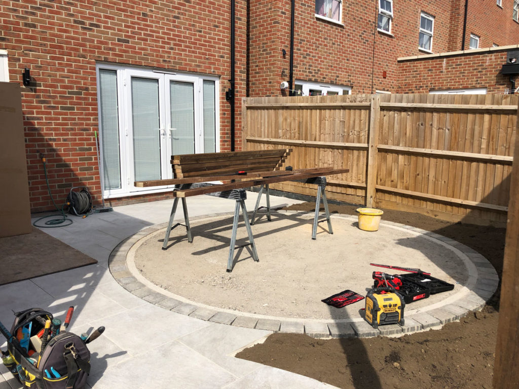 circular base for artificial turf surrounded by porcelain paving