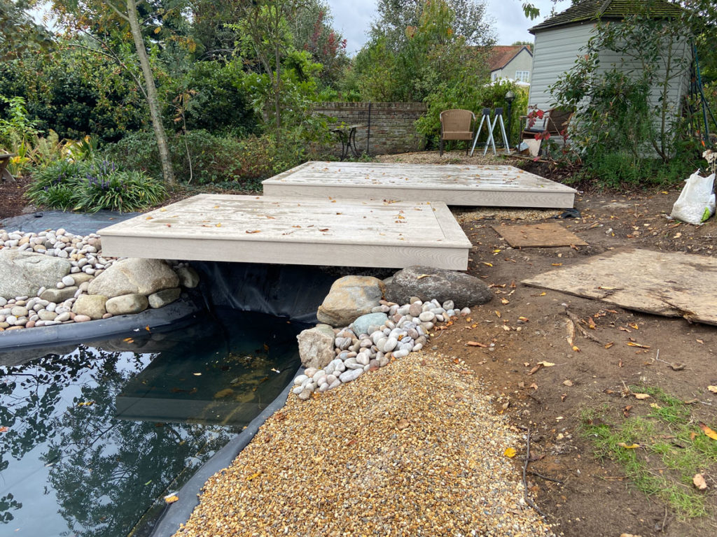 two offset composite decking squares over hanging a wildlife pond in tiptoe