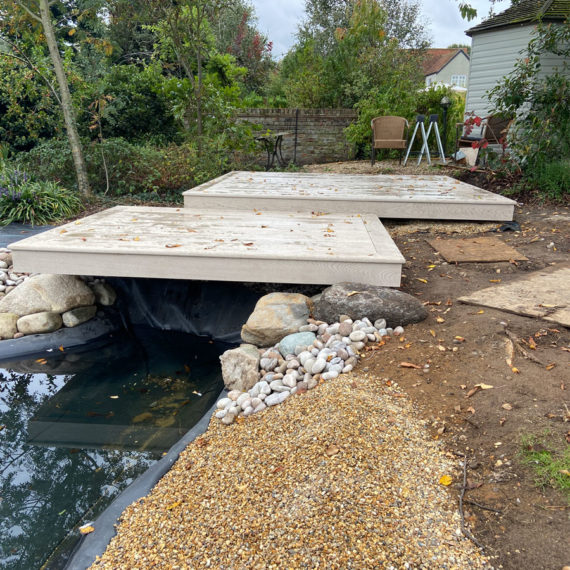 two offset composite decking squares over hanging a wildlife pond in tiptoe