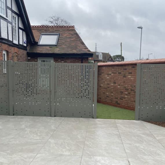 stylish pale grey porcelain patio with bespoke metal screening and gateway leading to courtyard garden beyond