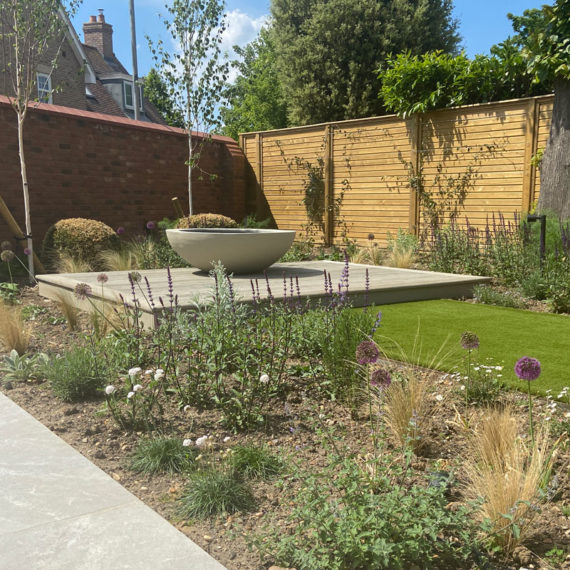 Pretty garden with modern planter as a focal point and lots of bee friendly planting