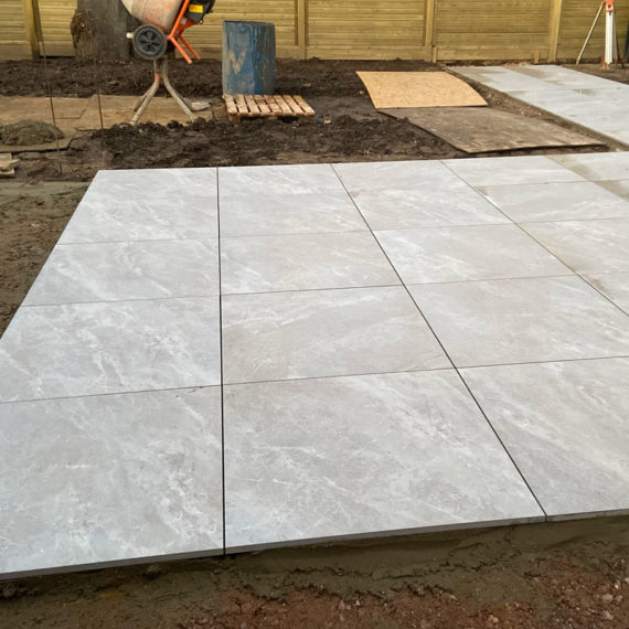 square porcelain outdoor tiles being laid to form a stylish modern patio