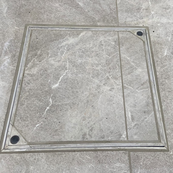 recessed manhole cover cleverly made to match porcelain patio