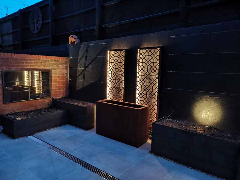 Decorative screens in a small modern garden, lit from behind to create a lovely ambience on the patios